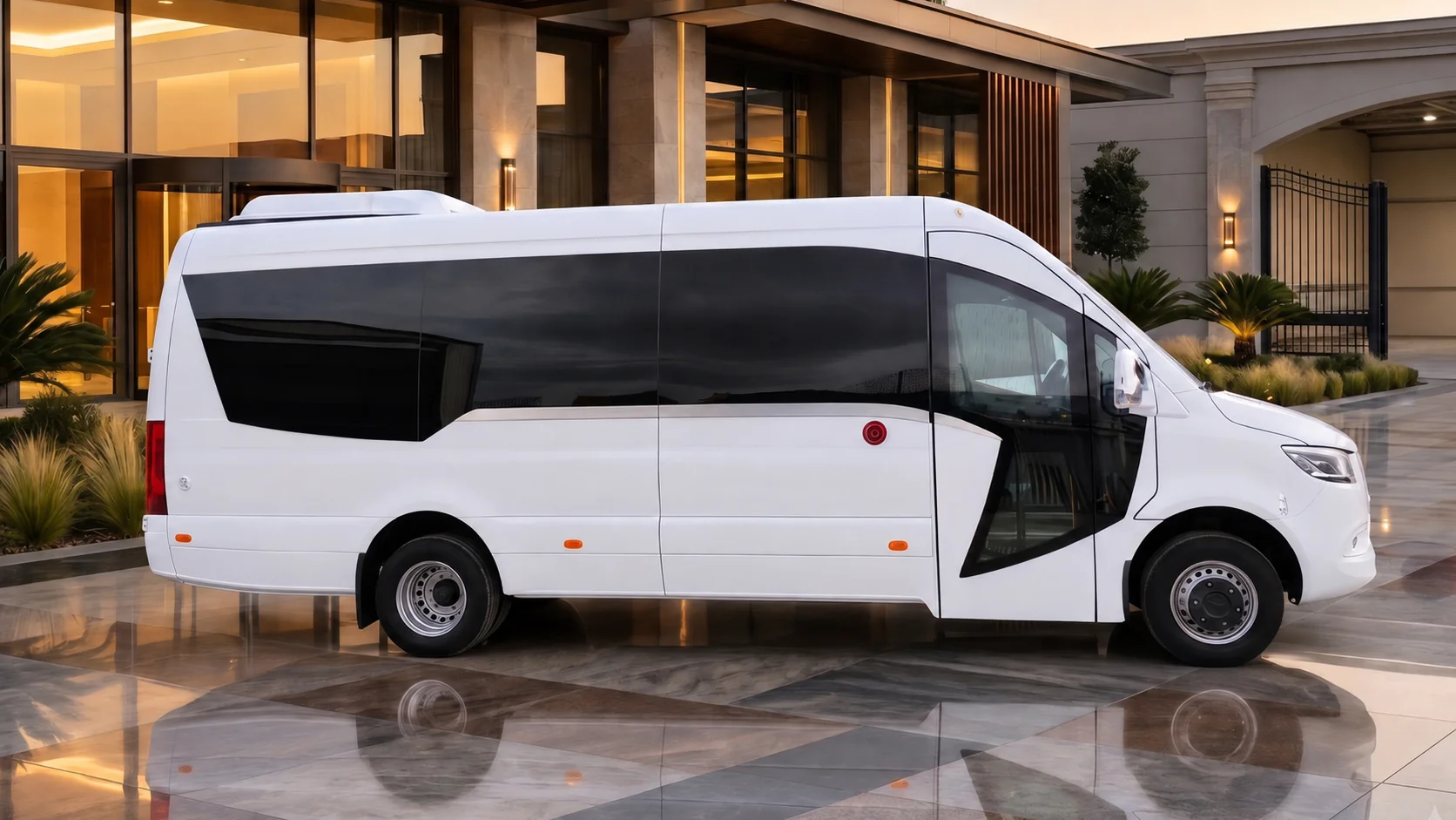 White Ilesbus Vegas minicoach outside a luxury venue at dusk
