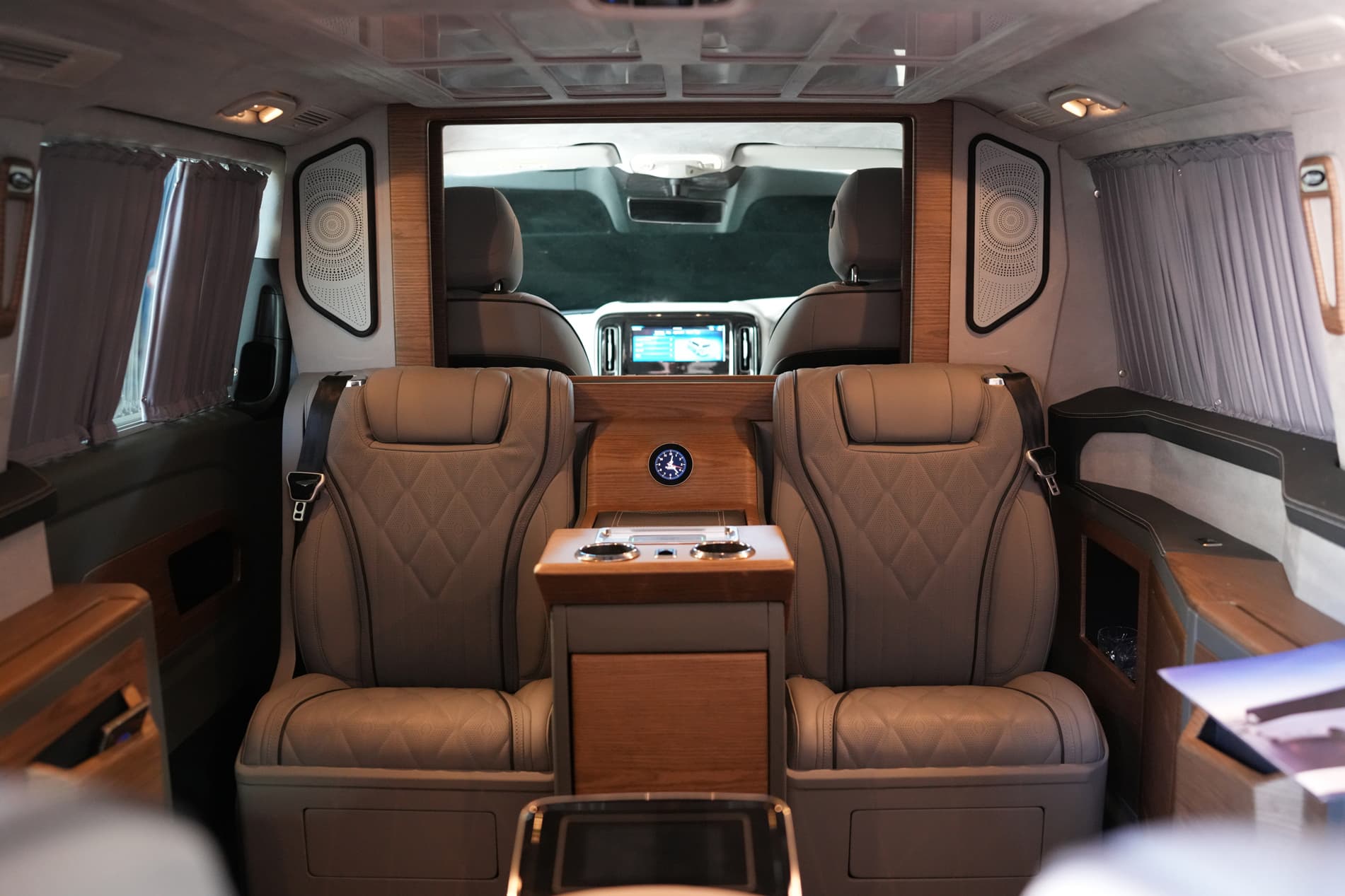Ilesbus Vito VIP cabin with two individual leather passenger seats, wood console and privacy curtains