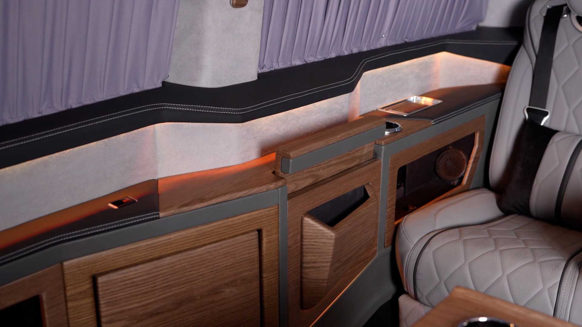 Bespoke wood side cabinetry, ambient lighting and leather seating inside the Ilesbus Vito VIP