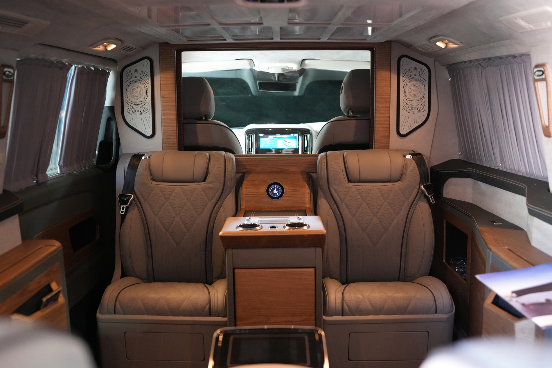 Ilesbus Vito VIP cabin with two individual leather passenger seats, wood console and privacy curtains