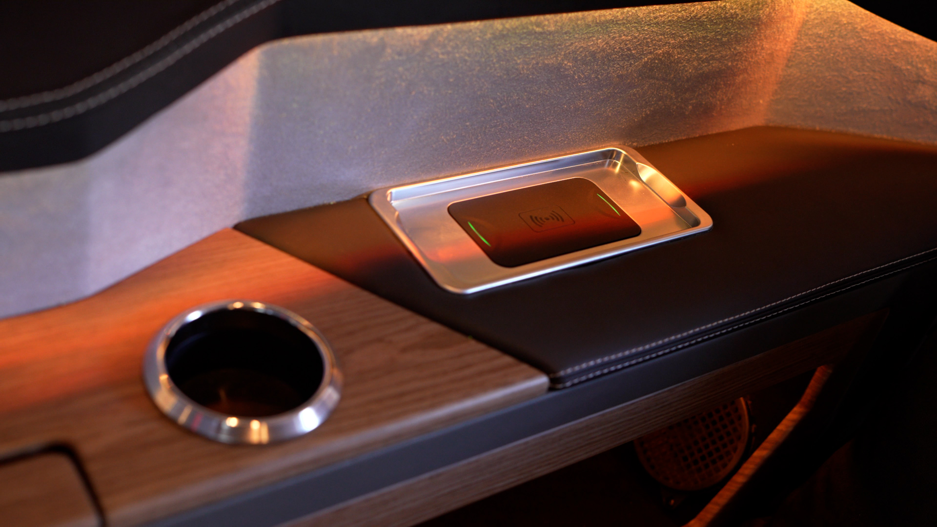 Integrated wireless charging pad and cupholder beside a Vito VIP passenger seat