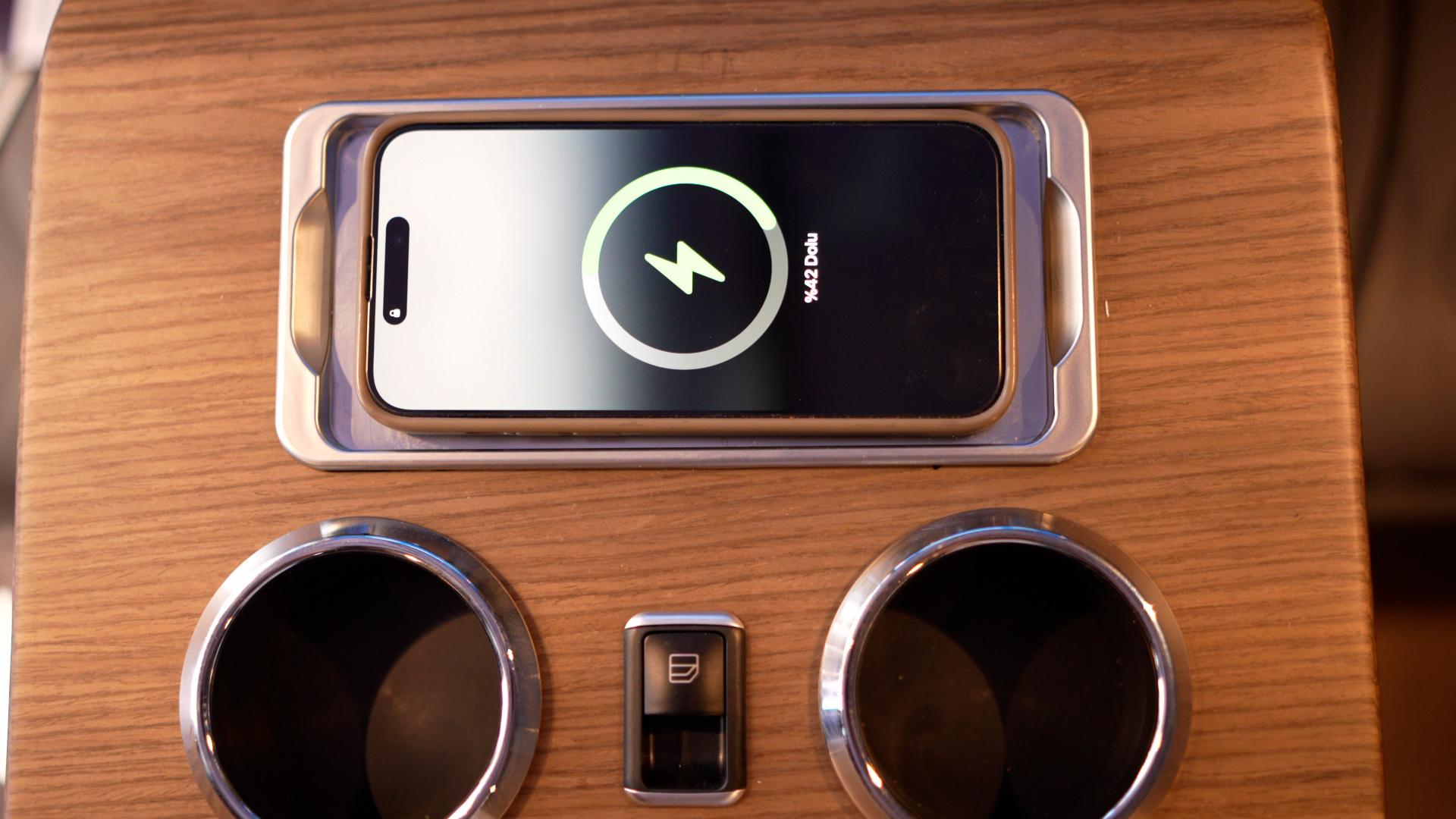 Smartphone charging wirelessly in the wood centre console of the Ilesbus Vito VIP
